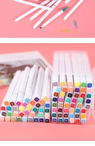Close-up of dual-tip water-based markers in a translucent storage box on pink background