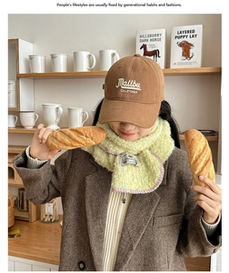 Gros plan d'une écharpe en laine jaune à coutures roses et d'une casquette Malibu marron