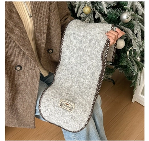 Détail d'une écharpe en laine grise avec point de feston marron et étiquette déco