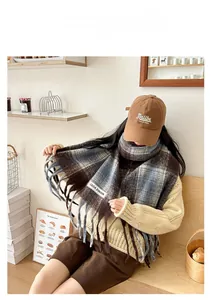 Detail of soft plaid mohair scarf with fringes and brand label in cozy indoor setting