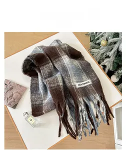 Detail shot of brown and blue plaid mohair scarf with soft tassels and woven label