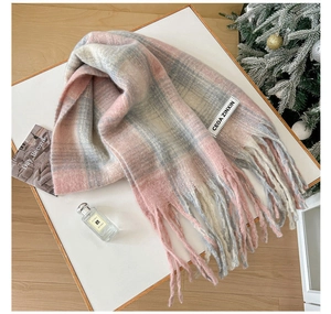 Detail of soft mohair plaid scarf with tassels and brand label in cozy winter setting