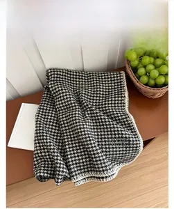 Détail d'une écharpe en cachemire à pied-de-poule noir et blanc avec bordure blanche