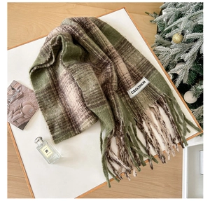 Detail of mohair checkered scarf with fringe and brand label in festive winter setting
