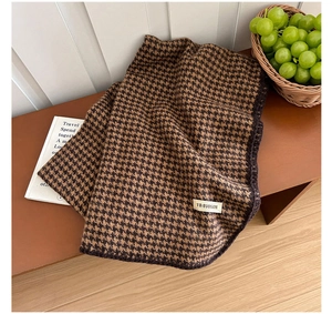 Détail d'une écharpe pied-de-poule vintage avec tissage marron et étiquette