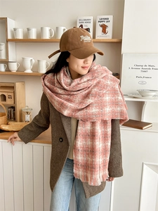 Close-up of pink plaid scarf with fringe tassels paired with embroidered baseball cap