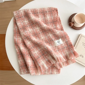 Detail of pink and white checkered knit scarf with fringe and soft cashmere texture