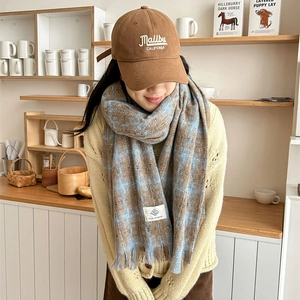 Brown Malibu baseball cap paired with a blue and brown plaid tassel scarf for winter warmth
