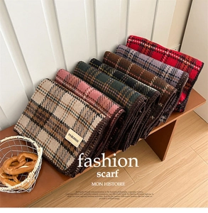 Detail of blanket stitch edges and classic plaid patterns on soft winter scarves
