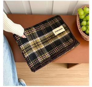 Close-up of vintage plaid scarf with stitched edges and rectangular fabric label