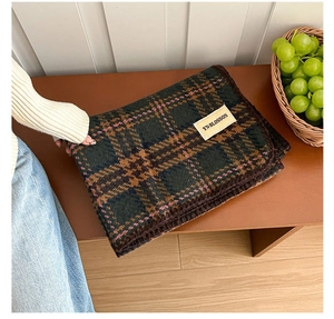 Detailed view of dark green plaid faux cashmere scarf with fine whipstitched edges