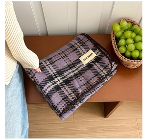 Close-up of vintage purple plaid scarf with decorative stitching and premium woven label