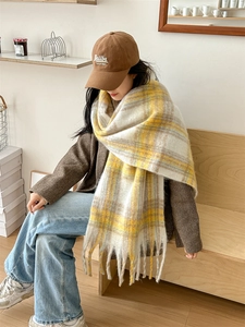 Gros plan d'une écharpe en mohair à carreaux jaunes avec franges et texture douce