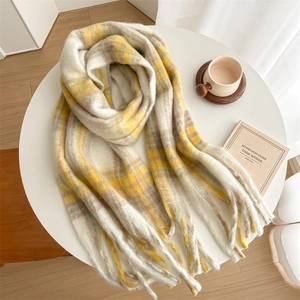 Détail d'une écharpe en mohair à carreaux jaunes et gris avec des franges