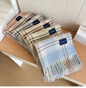 Detail of colorful plaid scarves with soft fringe and elegant classic woven label
