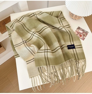 Detail of olive green checkered scarf with soft fringe tassels and woven brand label