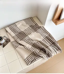 Gros plan des franges d'écharpe avec motif pied-de-poule classique marron et crème