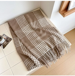 Gros plan sur l'écharpe à carreaux marron et blanc avec détails de franges douces