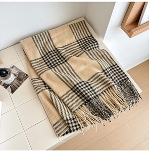 Gros plan de l'écharpe à carreaux beige et noir avec franges fines et texture douce