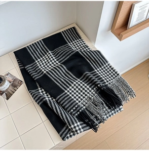 Détail de la texture d'une écharpe à carreaux noirs et blancs avec des franges élégantes