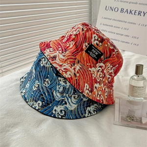 Detail of double-sided bucket hats featuring Japanese wave prints in red and navy blue