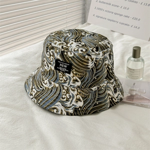 Detailed close-up of reversible bucket hat featuring wave patterns and woven side label