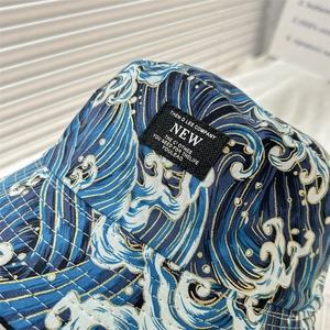 Close-up of double-sided bucket hat featuring blue Ukiyo-e wave patterns and stitching