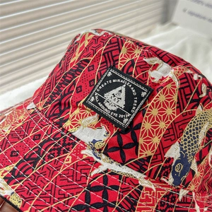 Detail of red Japanese style bucket hat with golden koi and wave embroidery patterns