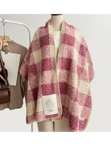Dettaglio della sciarpa in maglia a quadri rosa e beige con trama in pile ed etichetta tessuta