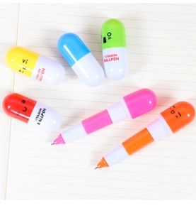 Close-up view of cute retractable capsule ballpoint pens with faces on lined notebook