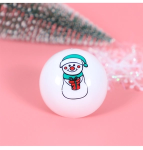 Nahaufnahme einer weißen Weihnachtskugel mit Schneemann-Motiv und festlichem Schal