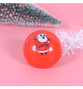 Nahaufnahme eines roten runden Spielzeugs mit Weihnachtsmann-Motiv und Feiertagsmuster