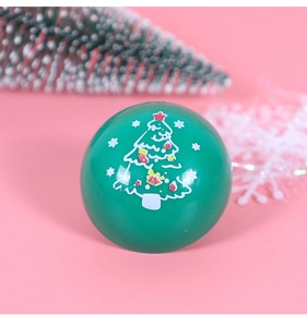 Nahaufnahme von grünem runden Weihnachts-Spielzeug mit Baummuster auf rosa Hintergrund