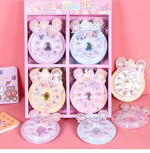 Close-up of cartoon girl nail stickers with heart gems in a pink display case