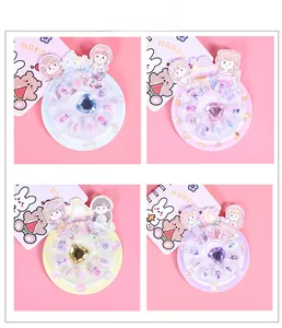 Detail view of colorful children's press-on nails featuring heart-shaped rhinestones and art
