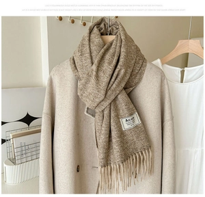 Texture détaillée d'une écharpe marron aspect cachemire avec franges sur un manteau