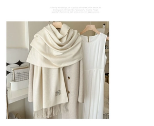 Détail de l'écharpe pashmina crème avec textures douces, franges et étiquette