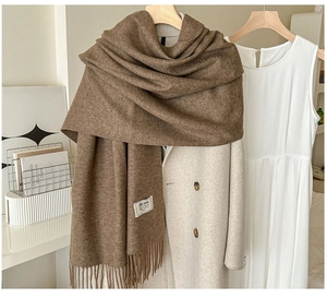 Détail de l'écharpe marron en cachemire synthétique avec franges et étiquette de marque