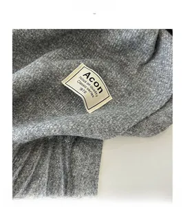 Détail d'une écharpe gris foncé aspect cachemire avec texture douce et étiquette de marque