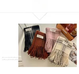 Detailed view of four classic plaid cashmere-like scarves with tassel fringe and elegant labels
