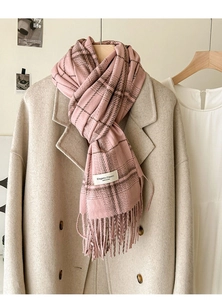 Detail of pink plaid cashmere-feel scarf with long tassels and elegant classic woven label