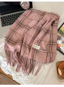 Detail of soft cashmere-feel pink and brown plaid scarf with fringe and elegant woven label