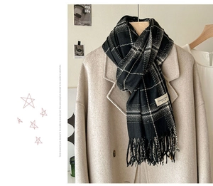 Detail of classic black and white checkered scarf with soft fringe and elegant woven label