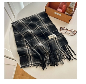 Close-up of classic black and white checkered scarf featuring soft fringe and elegant texture