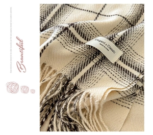 Close-up of beige plaid cashmere scarf with fringes and elegant fabric texture