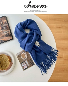 Macro shot of 100% wool label and fringe detail on the navy blue luxury winter scarf
