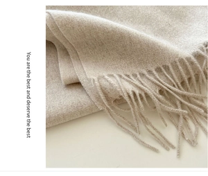 Macro detail of soft beige wool scarf texture and classic fringe trim decoration