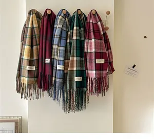 Vue détaillée de foulards à carreaux épais avec des franges douces et étiquettes
