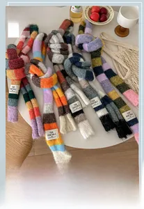 Macro detail of colorful striped knit scarves with soft fuzzy texture and brand woven label