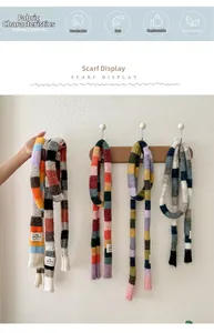 Detail view of colorful rainbow striped knit scarves with soft texture and logo tag